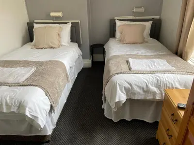 two beds sitting next to each other in a room at Somerville Hotel in Blackpool