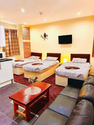 a hotel room with three beds and a couch at The Cabbage Hall Hotel in Liverpool