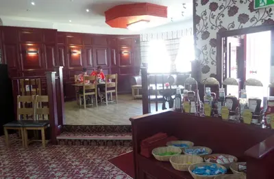 a woman sitting at a table in a room with a mirror at The Cabbage Hall Hotel in Liverpool