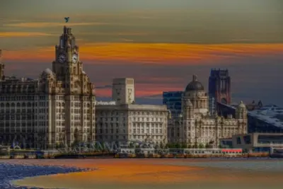 a group of buildings with a sunset in the background at Anfield Stadium House - Free Parking in Liverpool