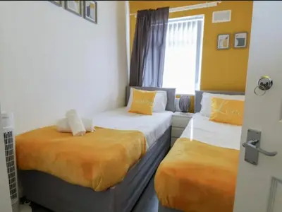 a room with two beds and a couch in it at Anfield Stadium House - Free Parking in Liverpool