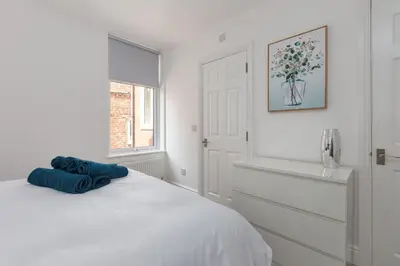 a white bedroom with a bed and a window at Lytham St Annes Luxury Apartment - No 1 Tides Reach in Lytham St Annes