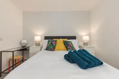 a bedroom with a white bed with two blue pillows at Lytham St Annes Luxury Apartment - No 1 Tides Reach in Lytham St Annes
