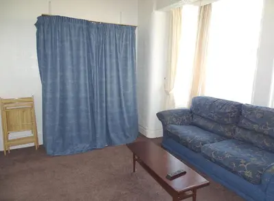 a living room with a blue couch and a table at Beeton Villas Holiday Apartments in Blackpool