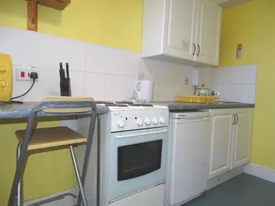 a kitchen with a white stove top oven next to a counter at Beeton Villas Holiday Apartments in Blackpool