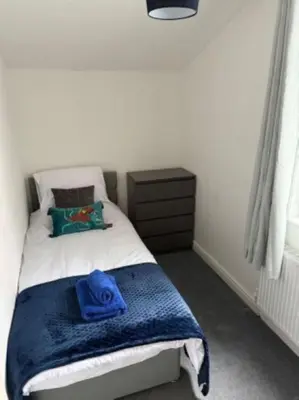 a bedroom with a bed with a blue hat on it at The Wordsworth in Barrow in Furness