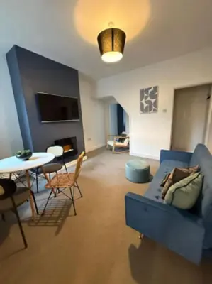 a living room with a blue couch and a table at The Wordsworth in Barrow in Furness