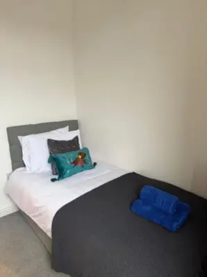 a bedroom with a bed with a blue pillow at The Wordsworth in Barrow in Furness