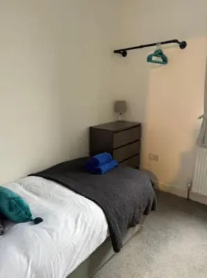 a bedroom with a bed and a dresser at The Wordsworth in Barrow in Furness