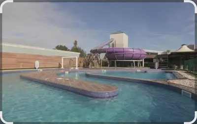 a swimming pool with a water slide in the middle at Dennys Holiday Home Pet Free in Blackpool