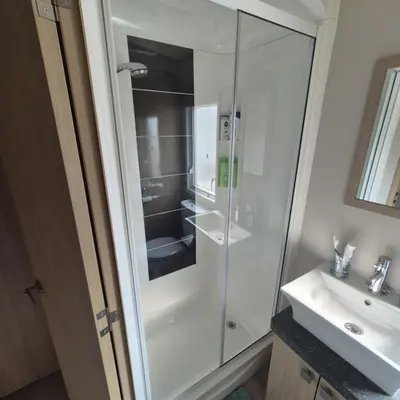 a glass shower in a bathroom with a sink at Dennys Holiday Home Pet Free in Blackpool