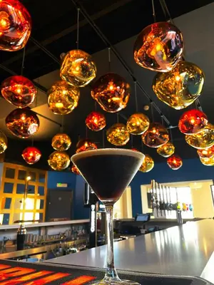 a martini glass sitting on top of a counter with lights at 272 Accommodation in Blackpool