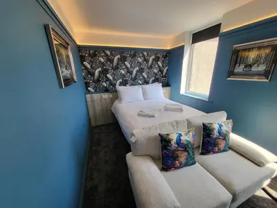 a blue room with a bed and a couch at 272 Accommodation in Blackpool