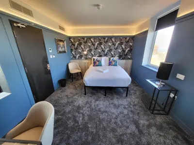 a bedroom with a bed and two chairs and a window at 272 Accommodation in Blackpool