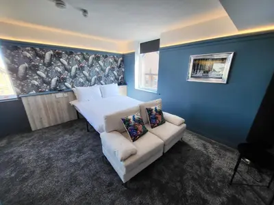 a bedroom with a white bed and a couch at 272 Accommodation in Blackpool