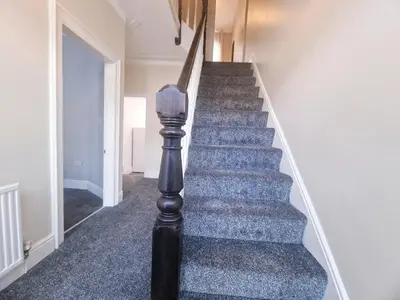 a staircase in a house with a blue carpeted floor at Upscale Luxury Home by Liverpool Football Stadium in Liverpool