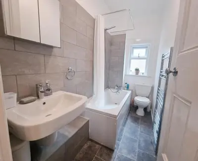 a white bathroom with a sink and a toilet at Upscale Luxury Home by Liverpool Football Stadium in Liverpool