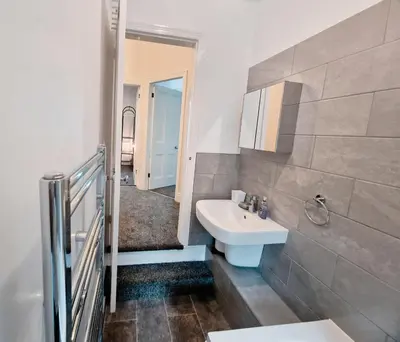 a white bathroom with a sink and a mirror at Upscale Luxury Home by Liverpool Football Stadium in Liverpool