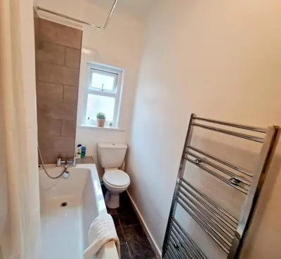 a bathroom with a tub and a toilet and a window at Upscale Luxury Home by Liverpool Football Stadium in Liverpool