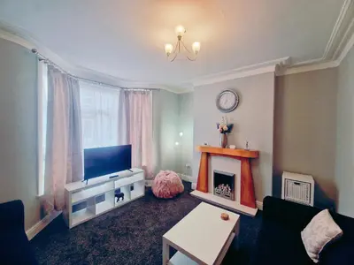 a living room with a television and a fireplace at Upscale Luxury Home by Liverpool Football Stadium in Liverpool