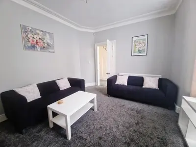 a living room with a couch and a table at Upscale Luxury Home by Liverpool Football Stadium in Liverpool