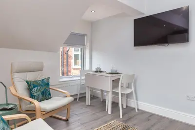 a living room with a table and a chair at Lytham St Annes Luxury Apartment - No 3 Tides Reach in Lytham St Annes