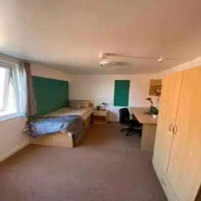 a small room with a bed and a desk and a desk at Elegant 4-Bedroom Apartment at Kexgill in Preston