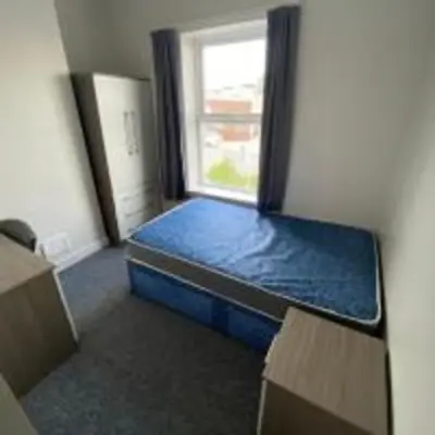 a small room with a bed and a window at Elegant 4-Bedroom Apartment at Kexgill in Preston