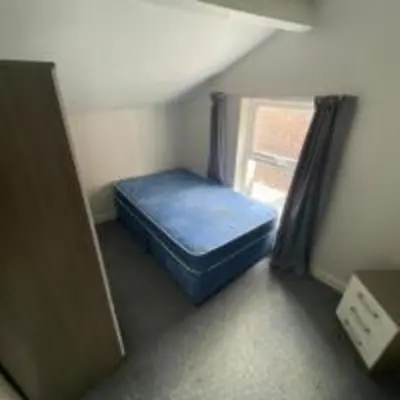 a small room with a blue bed and a window at Elegant 4-Bedroom Apartment at Kexgill in Preston