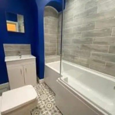 a bathroom with a toilet and a tub and a sink at Elegant 4-Bedroom Apartment at Kexgill in Preston