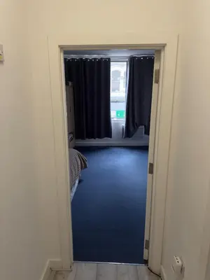 a hallway with a room with a bed and a window at Central Wigan Stay in Wigan