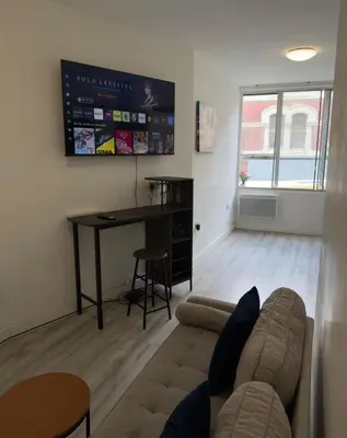 a living room with a couch and a desk at Central Wigan Stay in Wigan