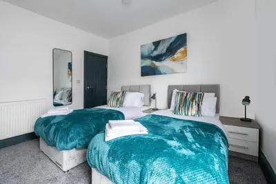 two beds in a bedroom with green blankets at Prime Location! 3-Bedroom House Near Anfield & Goodison Park in Liverpool