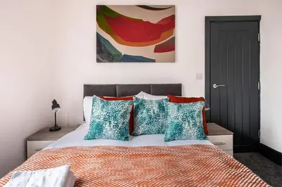 a bedroom with a bed and a painting on the wall at Prime Location! 3-Bedroom House Near Anfield & Goodison Park in Liverpool