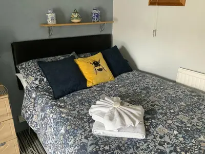 a bed with yellow pillows and a white towel on it at The Beechwood in Blackpool