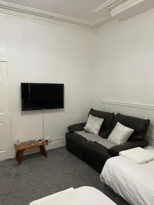a living room with a couch and a flat screen tv at The Beechwood in Blackpool