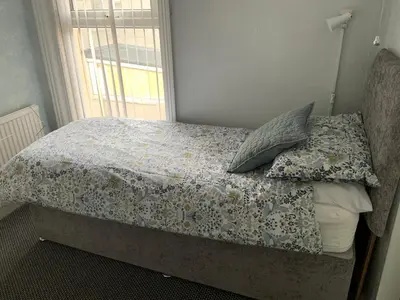 a bed with two pillows and a window in a bedroom at The Beechwood in Blackpool