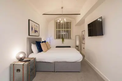 a bedroom with a large bed and a television at Liverpool Gem, Spacious 2BR Apt, Sleeps 8 in Liverpool