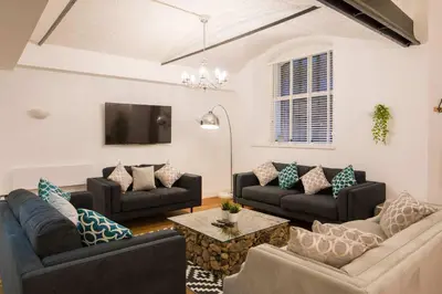 a living room with two couches and a table at Liverpool Gem, Spacious 2BR Apt, Sleeps 8 in Liverpool