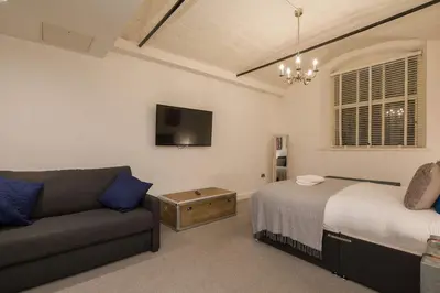 a living room with a bed and a couch at Liverpool Gem, Spacious 2BR Apt, Sleeps 8 in Liverpool