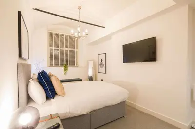 a bedroom with a bed with a tv on the wall at Liverpool Gem, Spacious 2BR Apt, Sleeps 8 in Liverpool