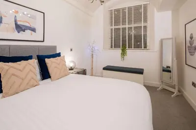 a bedroom with a white bed and a window at Liverpool Gem, Spacious 2BR Apt, Sleeps 8 in Liverpool