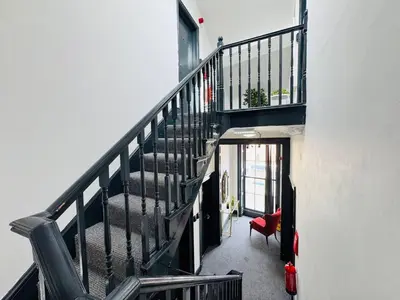 a staircase in a house with a red chair at Pembroke Place Private room 5 in Liverpool