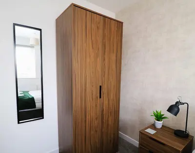 a wooden cabinet in a bedroom with a mirror at Lancaster 2 Bedroom House - Driveway Parking in Lancaster