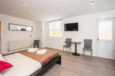 a bedroom with a bed and two chairs and a desk at The Moscow Studios in Liverpool