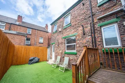 a backyard with chairs and a wooden fence at The Moscow Studios in Liverpool