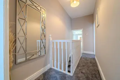 a hallway with a mirror and a staircase at Sleeps 7- Spacious 3 Bed House w Free Parking in Liverpool