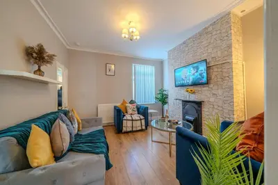 a living room with a couch and a fireplace at Sleeps 7- Spacious 3 Bed House w Free Parking in Liverpool