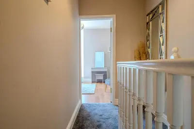 a hallway with a stairway leading to a room at Sleeps 7- Spacious 3 Bed House w Free Parking in Liverpool