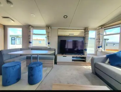 a living room with a couch and a table and a tv at Ocean Edge 13 in Heysham
